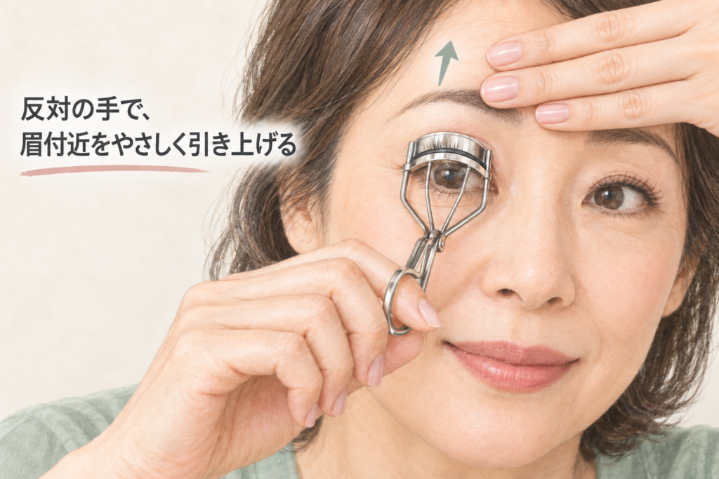 反対の手の3本指で眉付近をやさしく引き上げるビューラーの使い方